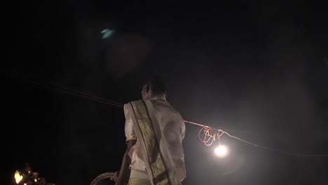 indian man waving ceremonial candelabra