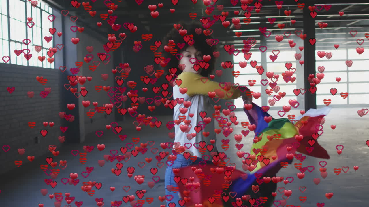 Woman wrapping rainbow pride flag in industrial loft, hearts floating across scene for marketing