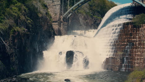 wide shot of bottom of new croton dam with powerful waterfall and stepped spillway leading down to the river. static. slow motion 40