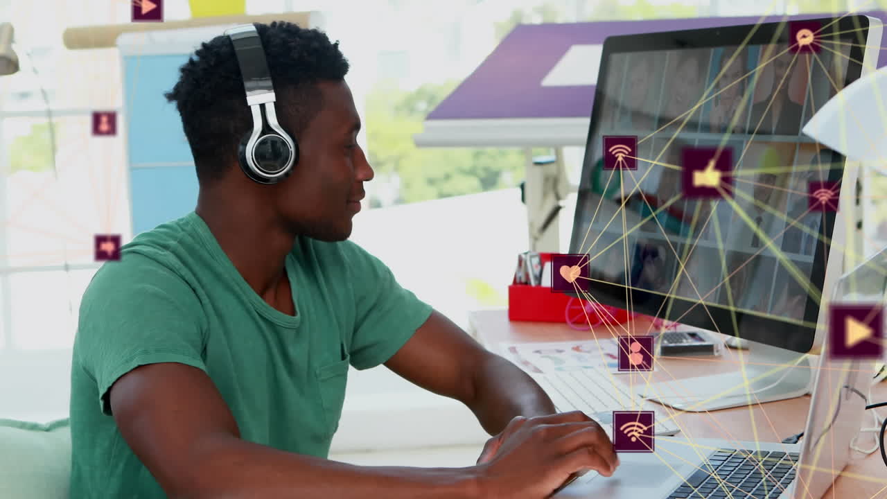 Animation of connected dots forming globes over african american man listening to music and working