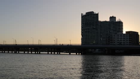 time-lapse of sunset behind urban buildings and bridge