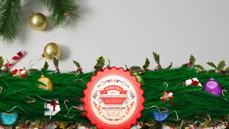 Animation-of-merry-christmas-text-banner-over-christmas-gifts-and-decorations-on-grey-surface