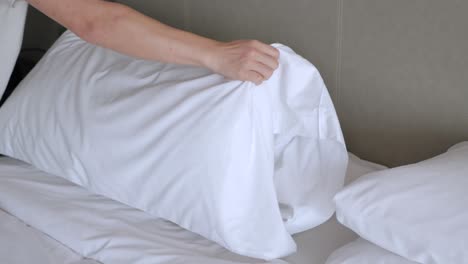 Concepto-De-Servicio-De-Hotel,-El-Ama-De-Llaves-Arregla-La-Almohada-En-La-Cama-Con-Una-Sábana-Blanca,-Hace-La-Cama-Por-La-Mañana