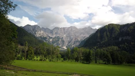 kamnik savinja alps from jezersko, slovenia, clouds above mountains and meadows with trees in front