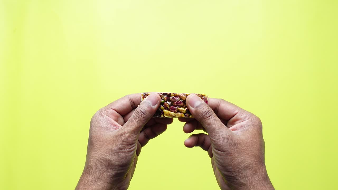 las manos sosteniendo un dulce de pistacho