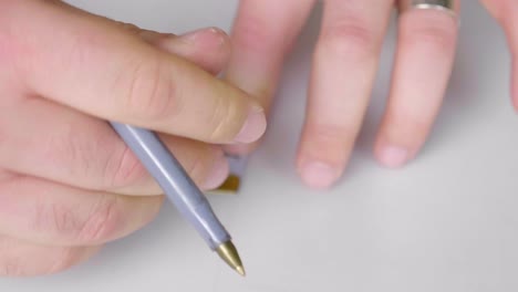 caucasian hands making marking on white paper with