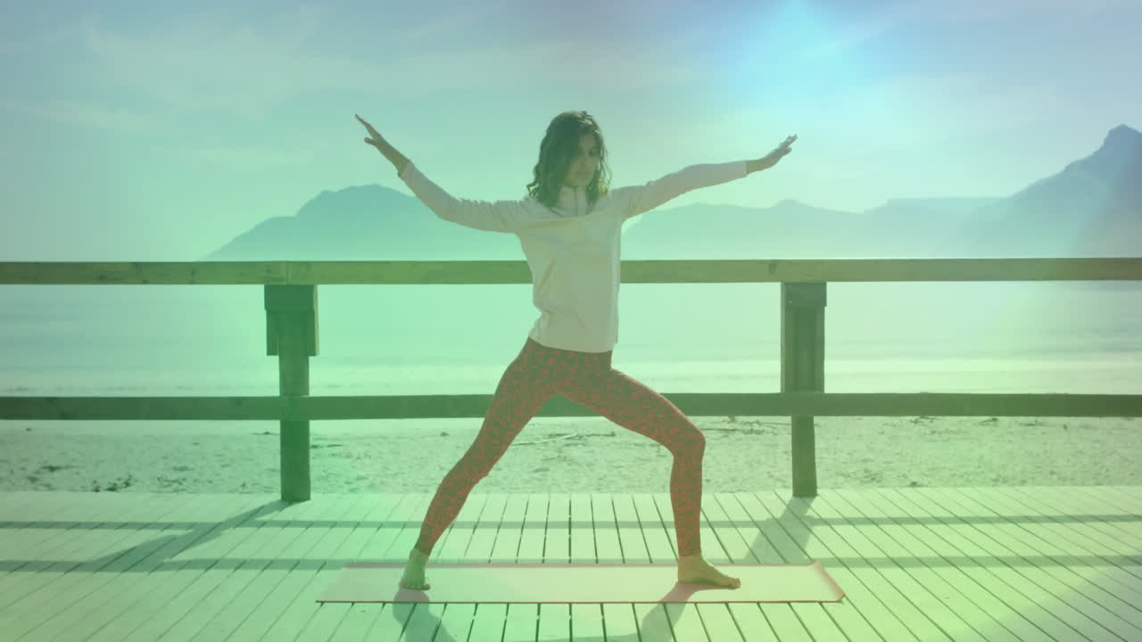 woman practicing yoga on wooden deck by beach, with animated heart icon floating over health chart