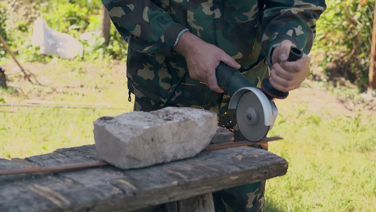 클로즈업 빌더는 금속 조각을 자르기 위해 디스크 사를 사용합니다.
