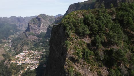 pequeño pueblo en un valle verde en madeira, punto de vista en una gran montaña verde, gran montaña, portugal, avión no tripulado, aéreo