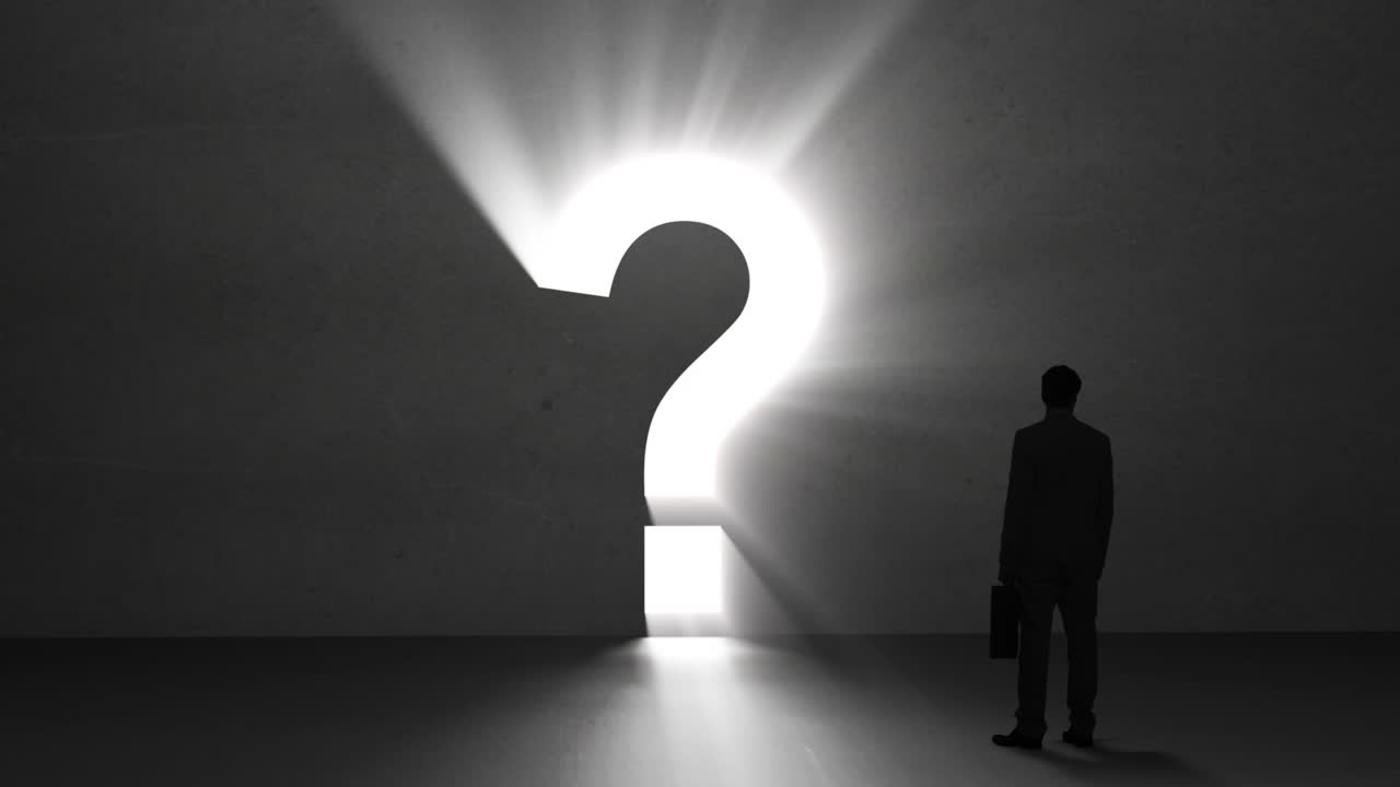 un hombre de negocios mirando un signo de interrogación gigante.
