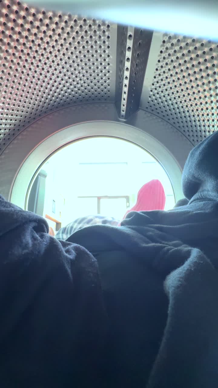 Teenager loading clothes into a washing machine