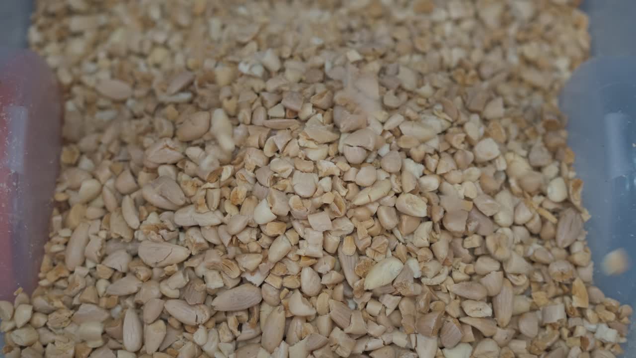 공장에서 통으로 떨어지는 으깬 아몬드 클로즈업