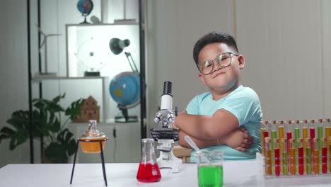 cute little scientist looking at microscope and pose in laboratory experiment with liquid