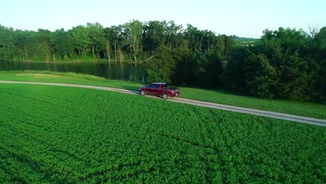 red pickup truck on a country road by the lake
