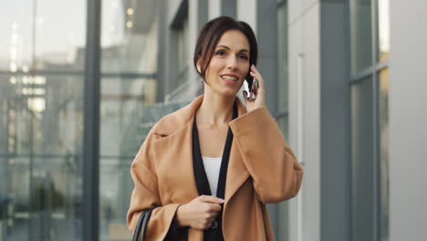 Vista-Frontal-De-La-Mujer-De-Negocios-Hablando-Por-Teléfono-Mientras-Camina-Por-La-Calle