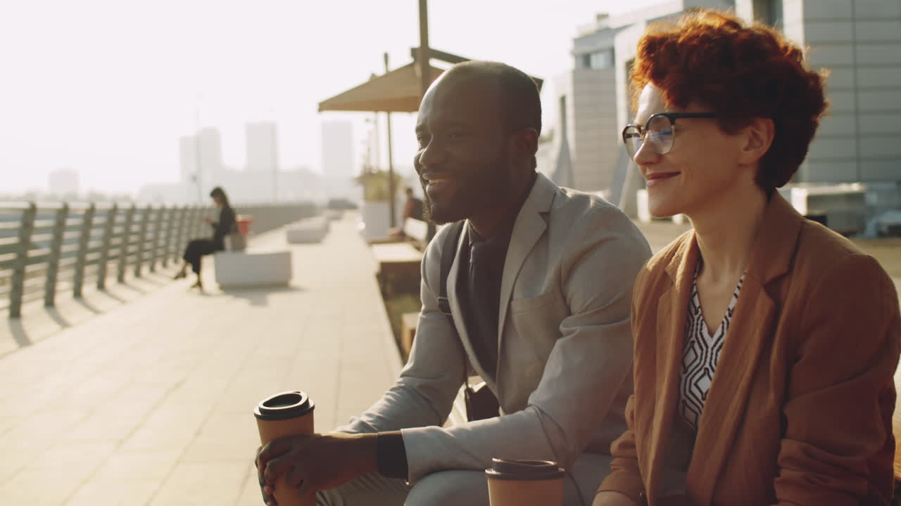 Diverse kolleger taler over kaffe på en bypromenade.