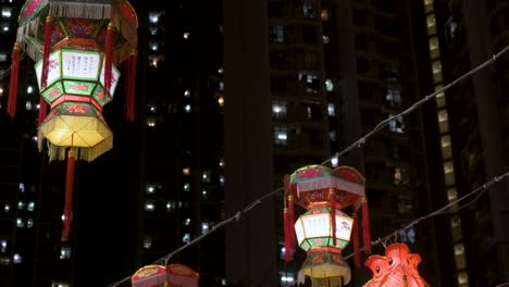 Chinese-lanterns,-which-symbolize-prosperity-and-good-fortune,-hang-from-ceiling-wires-near-a-residential-urban-area-during-the-Mid-Autumn-Festival,-also-called-Mooncake-Festival