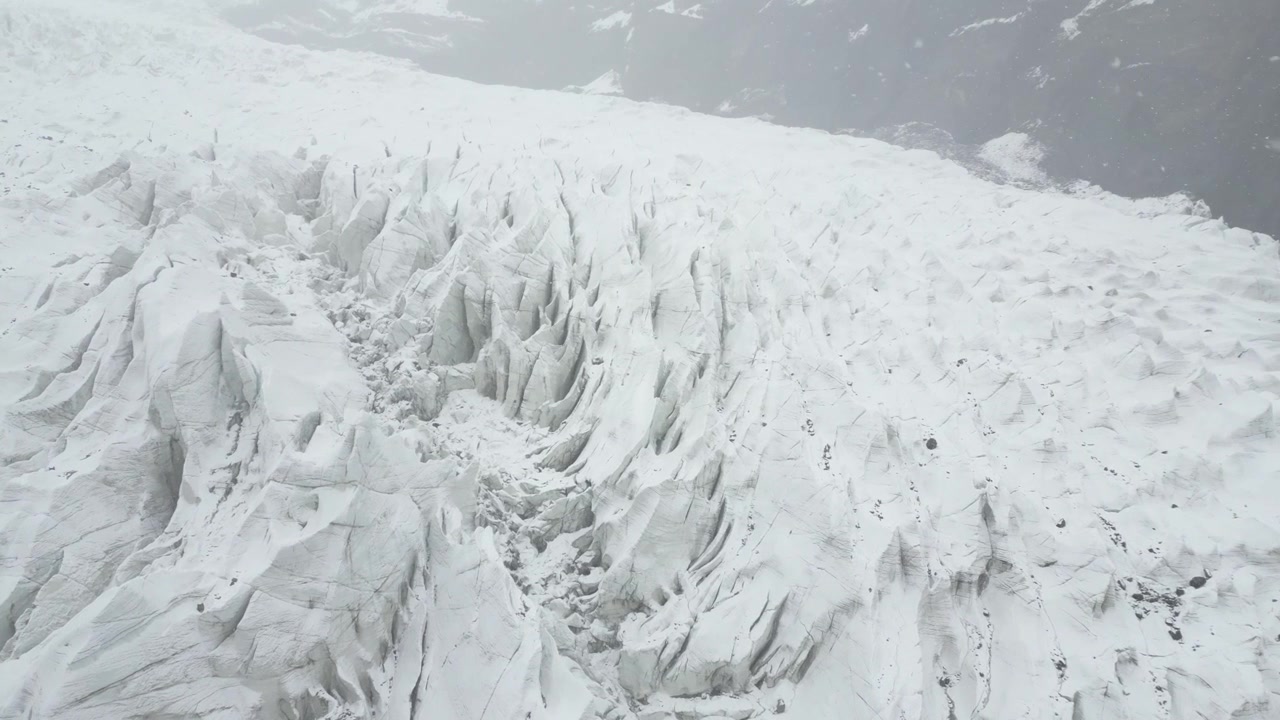 Imagens aéreas detalhadas voando sobre a superfície de gelo áspera da Geleira Passu, destacando texturas congeladas e formações glaciais nas Montanhas Karakoram.