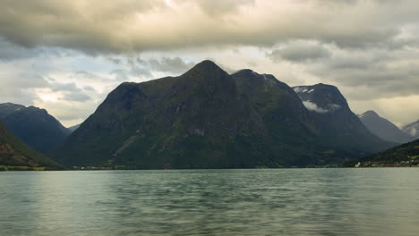 clouds over strynsvatnet lake and dramatic mountains in norway