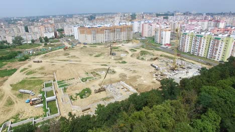 builders are working on the construction of a high-rise building in the city on the background of building materials, machinery and equipment. aerial view