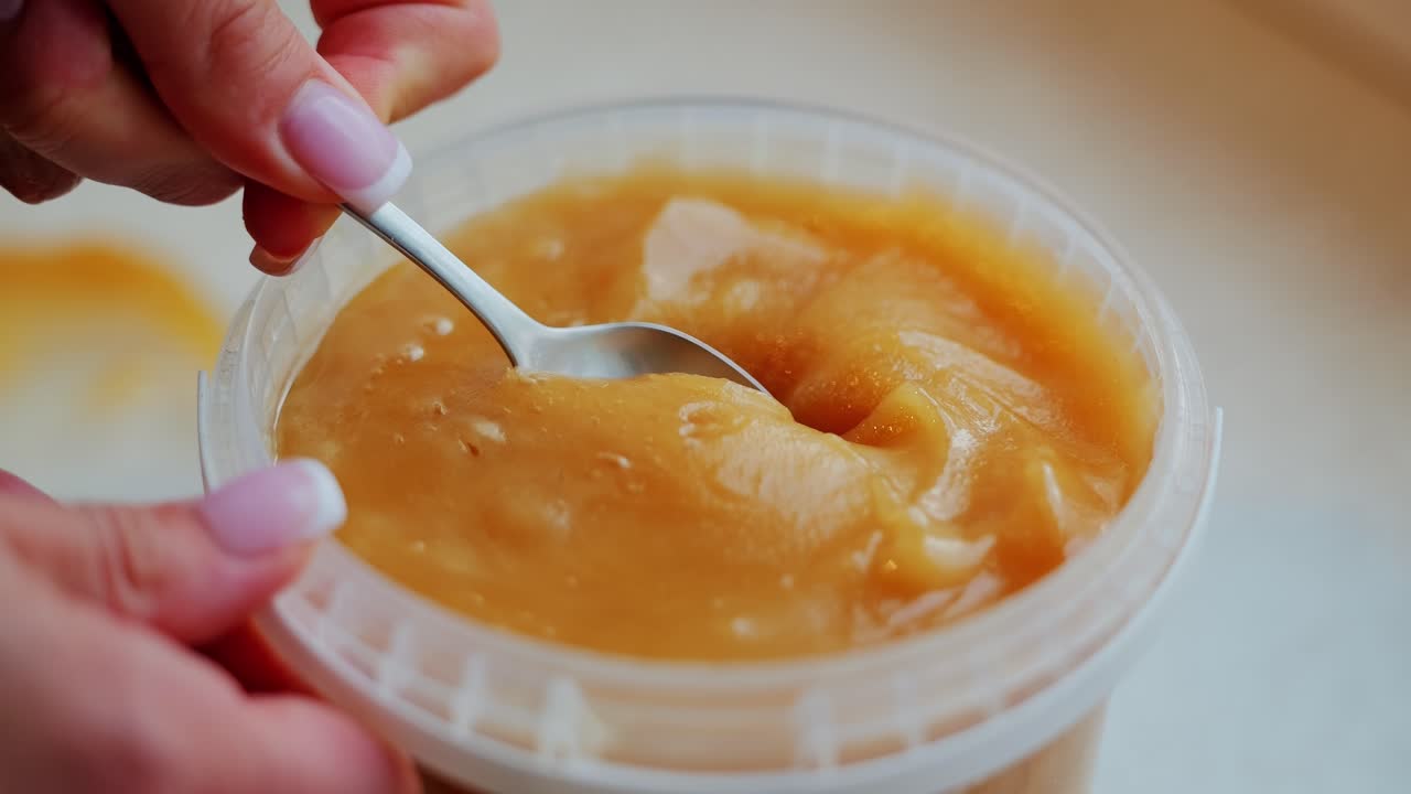 Golden honey harvested in Latvia scooped slowly in smooth motion close up frame