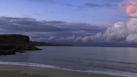 el lapso de tiempo de la puesta de sol de las olas que se estrellan sobre una playa de arena