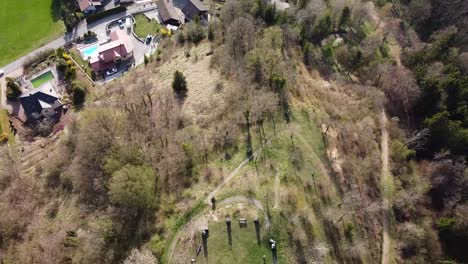 toma de drones de una capilla rodeada de lápidas en la cima de una colina con un pueblo y un lago