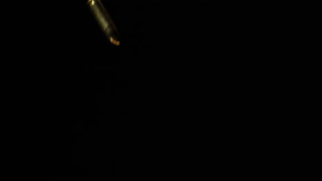 dropping 9mm luger bullets in dark background