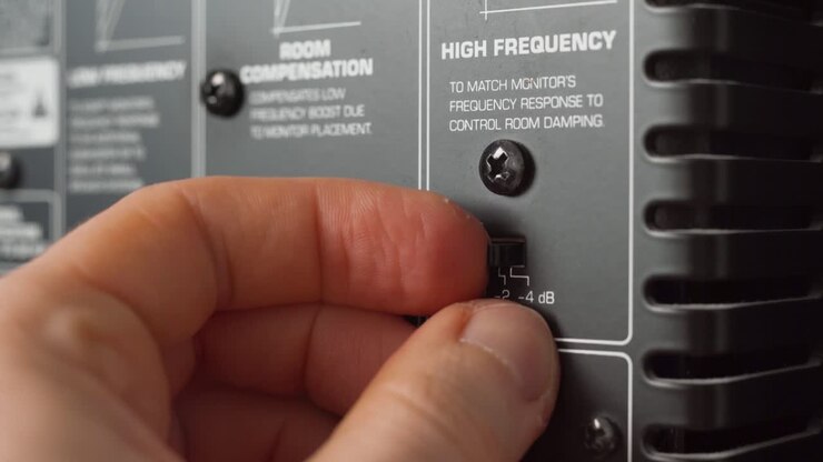 Man adjusting the audio settings of a studio monitor
