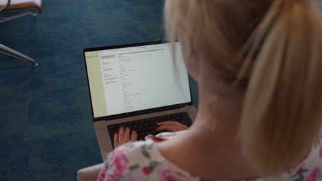 woman using laptop in airport lounge, working and browsing the web before her flight