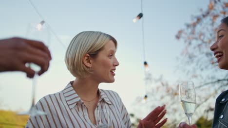 carefree woman relaxing rooftop party closeup. talking girl holding drink glass