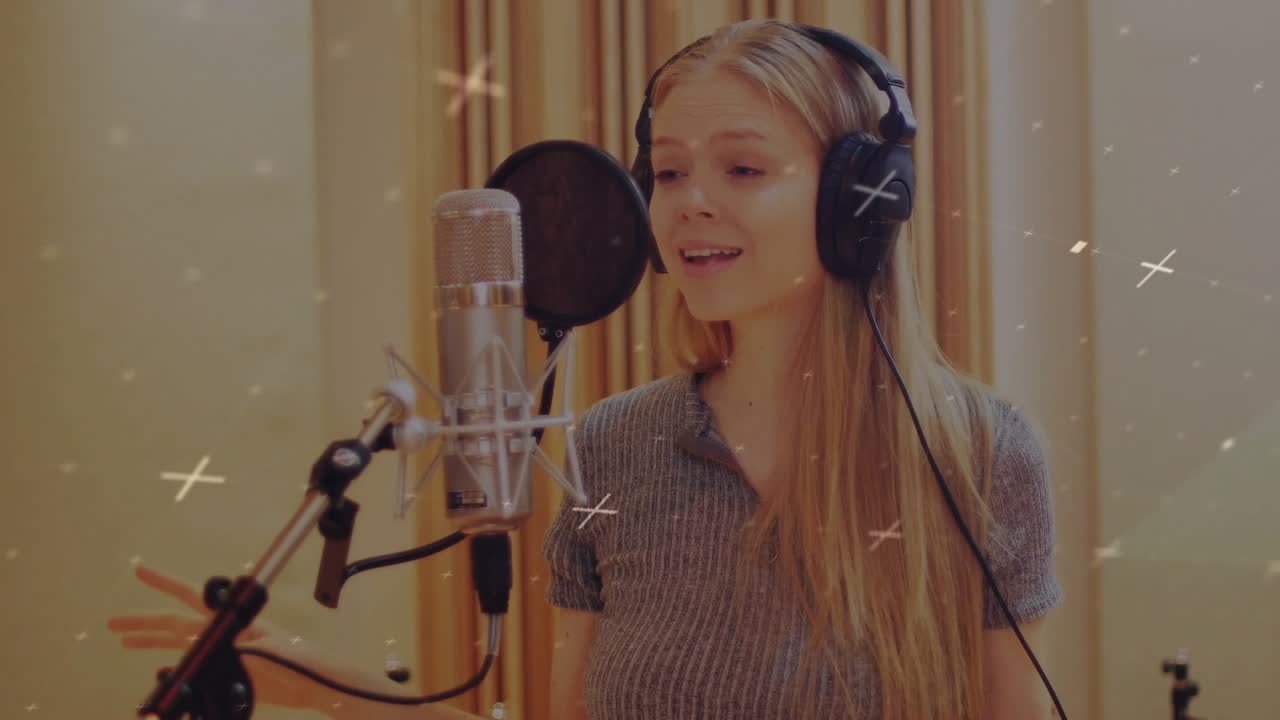 Female vocalist starting vocal take in booth, singing into mic, animating sparkles around singer