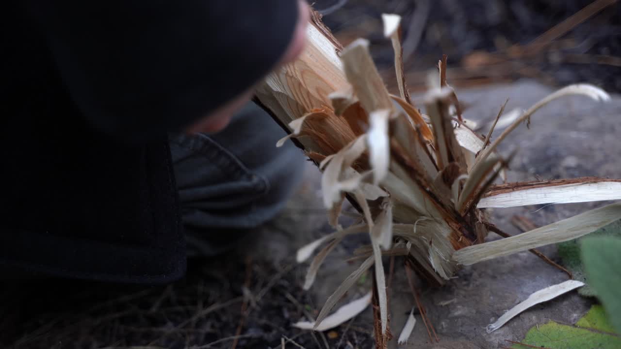 hombre blanco afeitando bosques para preparar el fuego.