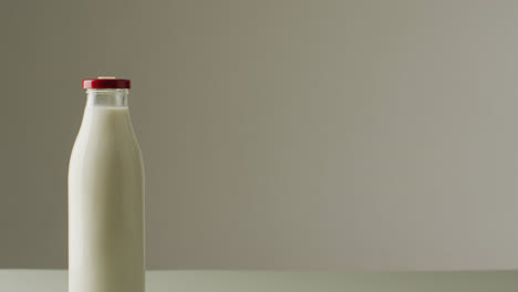 video of glass bottles of milk on white background