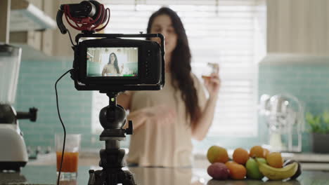 a-young-woman-recording-herself-in-the-kitchen