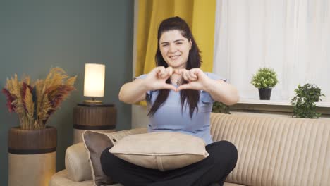 mujer haciendo el símbolo del corazón para la cámara.