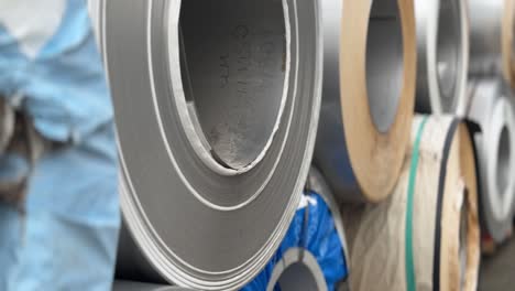 steel coils are stocked in the real warehouse. an industrial workshop and warehouse are needed for the storage and distribution of products from a metallurgical plant. type a