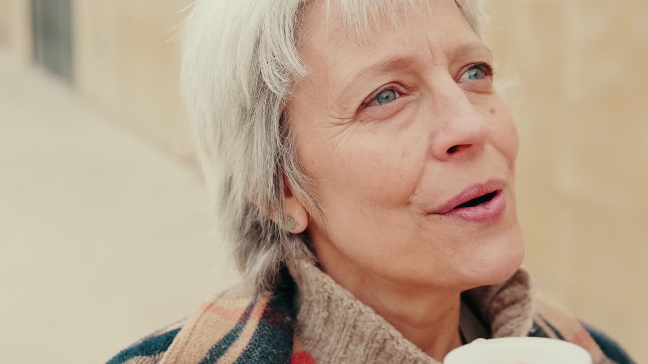 Close-up of Happy Senior Woman Talking and Drinking Coffee Outdoors