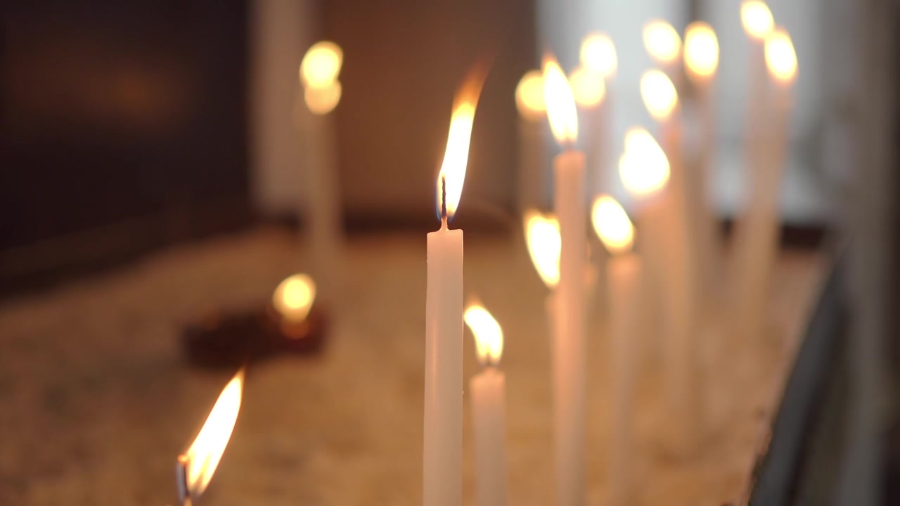 Fiamme tremolanti di candele bianche in un ambiente spirituale