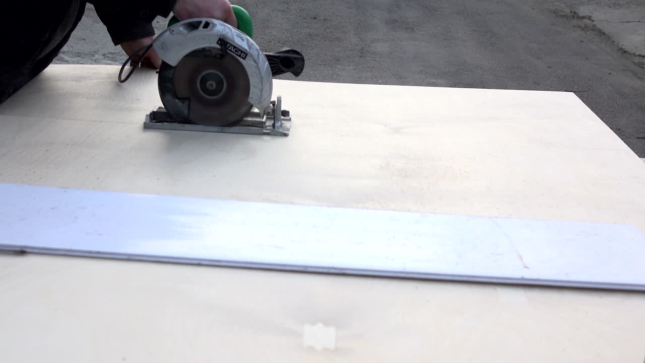 Taglio del legno con una sega elettrica a mano. Lavorazione del legno