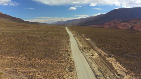 aerial - epic shot of a highway in the middle of a valley surrounded by mountains