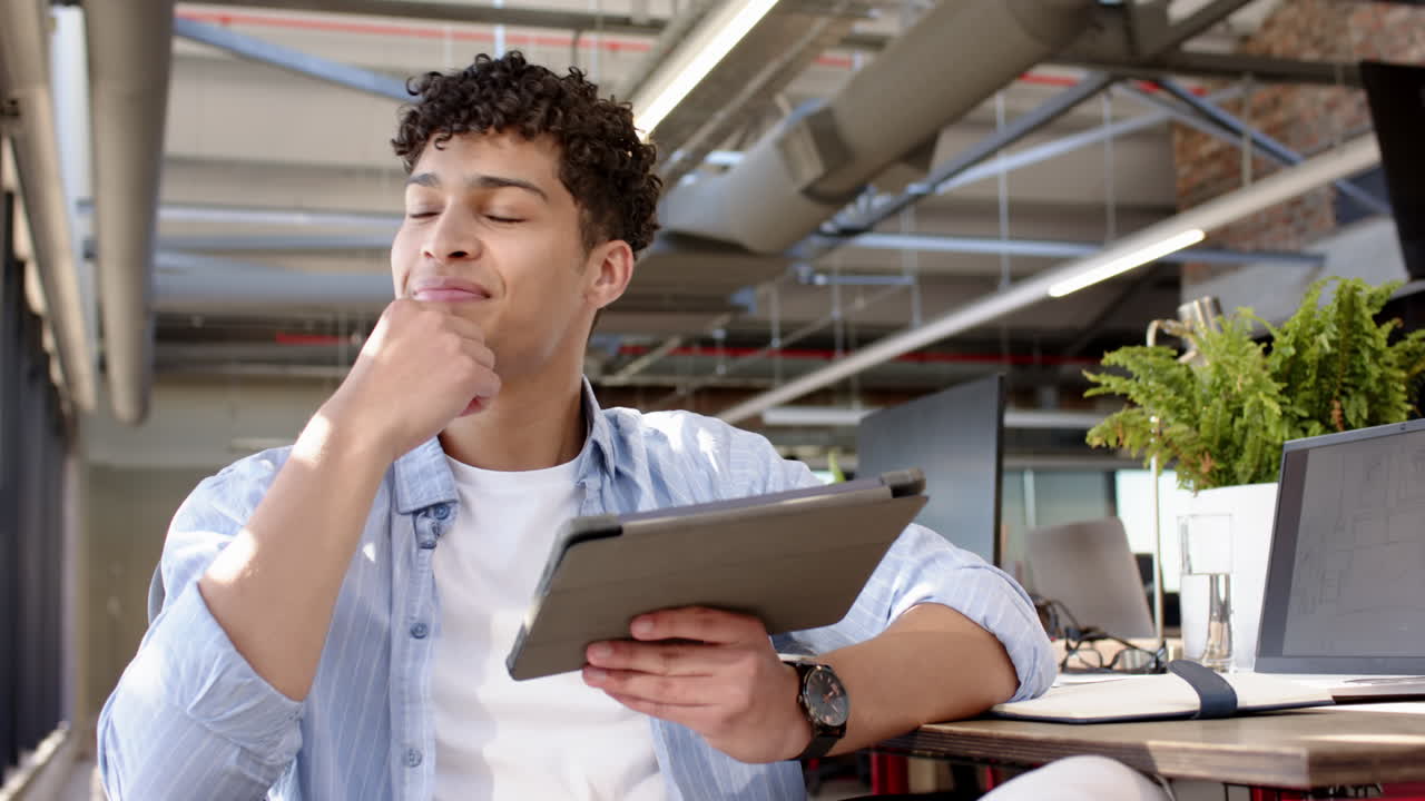 Smiling man using tablet in modern office, working on interior design project, copy space