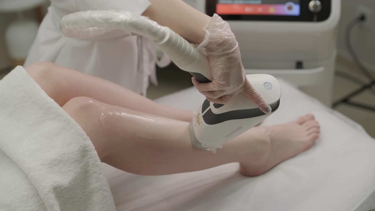 미용실에서 레이저 제거 및 화장품. 화장품, 스파 및 탈모 개념. 여성 다리의 레이저 탈모 절차. 장갑을 입은 의사.