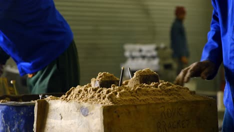 worker filling sand into the mold 4k