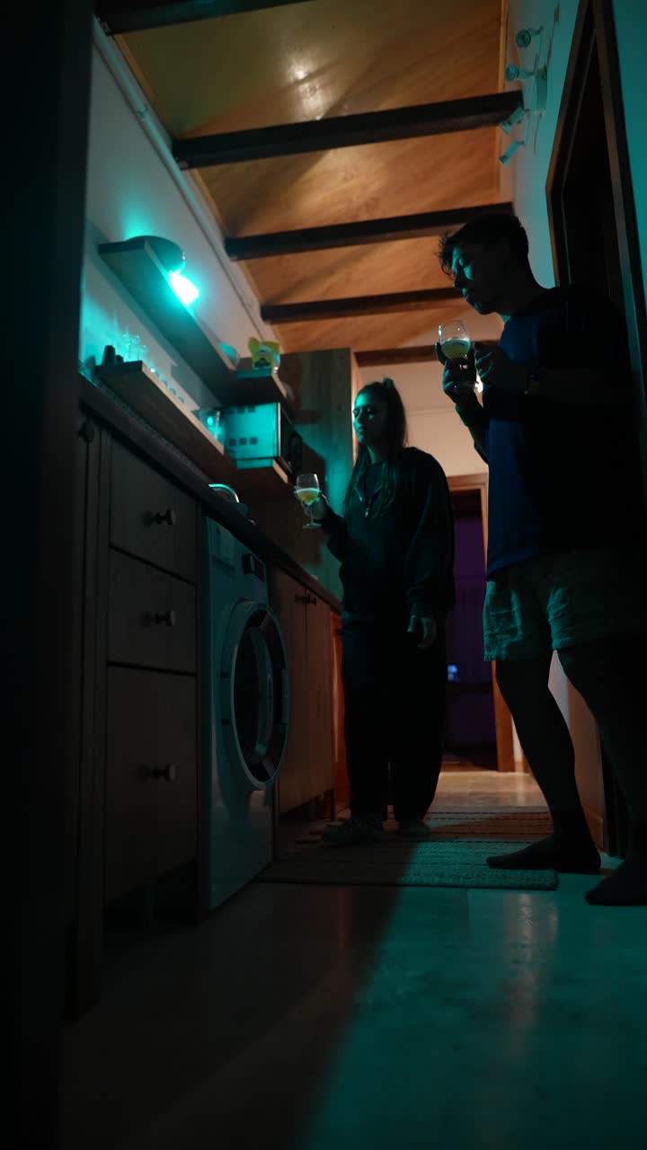 una pareja en una cocina nocturna.