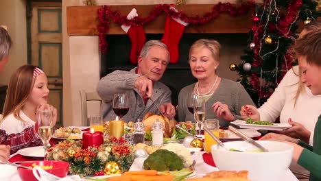 Familia-De-Tres-Generaciones-Cenando-Juntos-De-Navidad