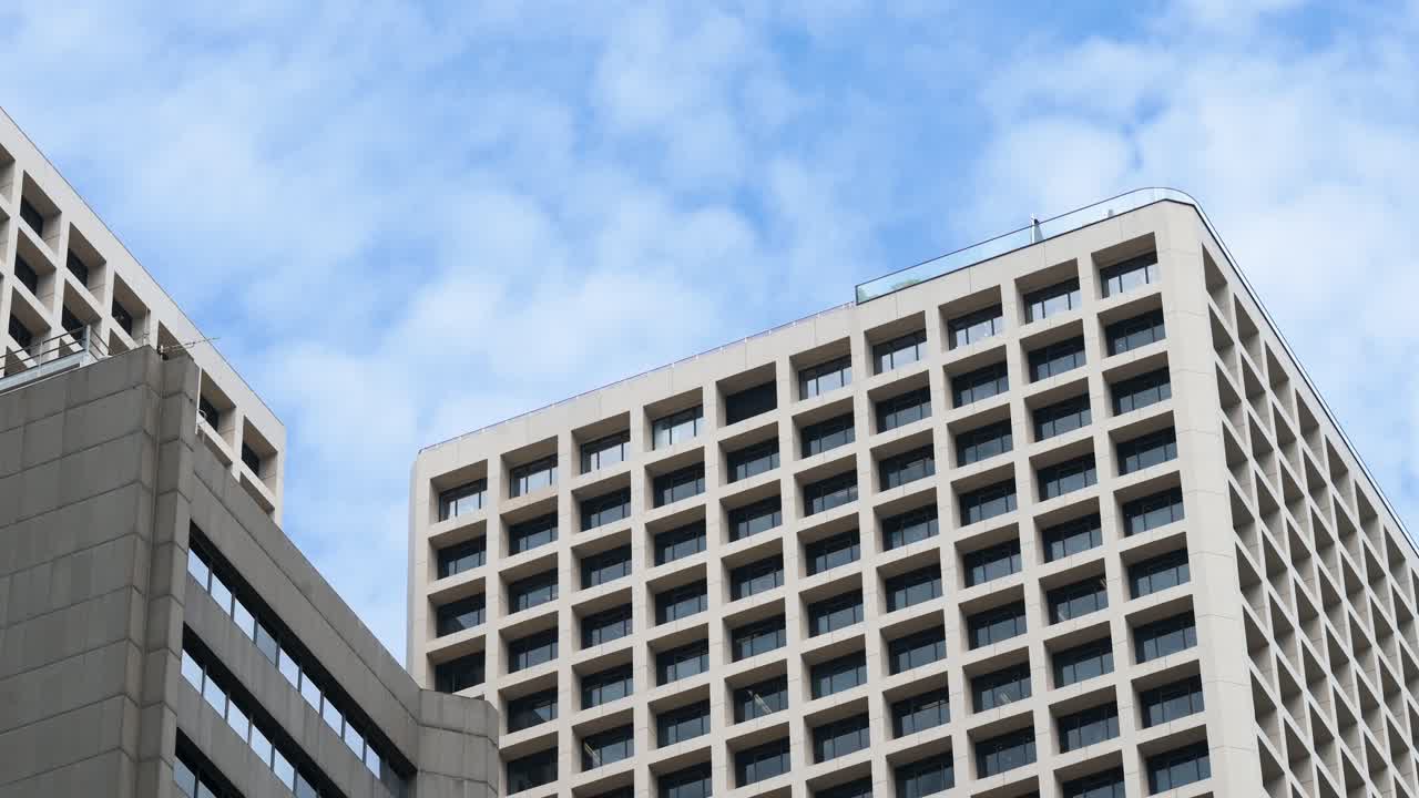 Upward view of business buildings in Hong Kong’s Central financial district, China, on a clear blue sky day.