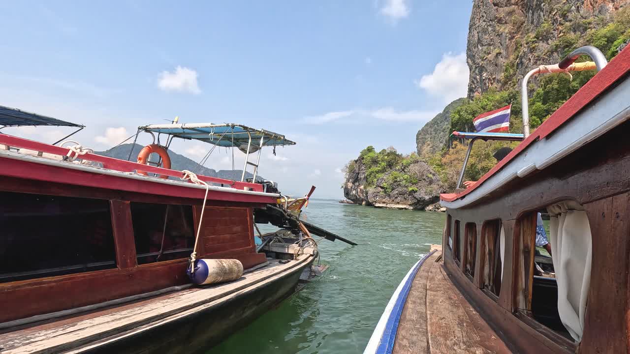 울창 한 초록색 과 바위 절벽 을 가로질러 보트 를 타고 항해 하는 것