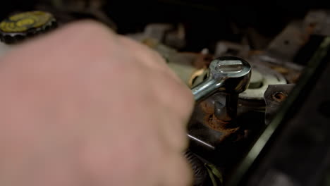 professional car mechanic screwing details of car with special tool