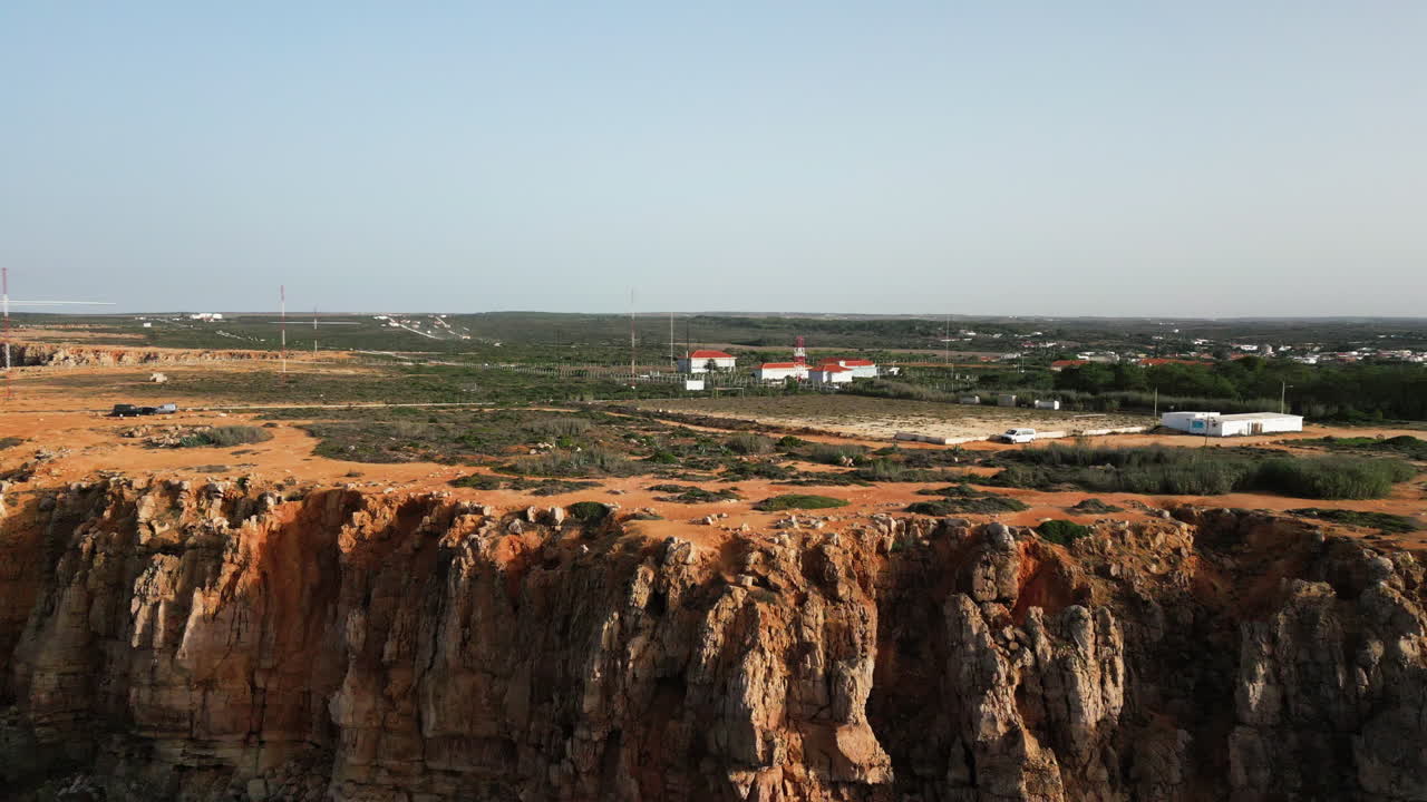 disparo de drones volando hacia atrás revelando los acantilados de sagres portugal